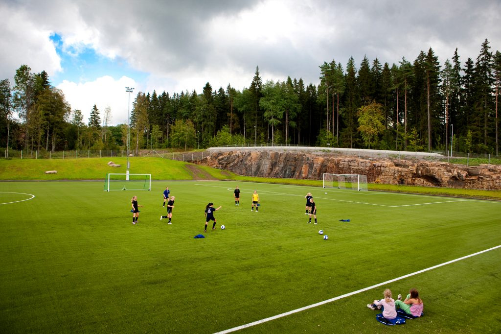 Bild på ungdomar som tränar på en fotbollsplan.