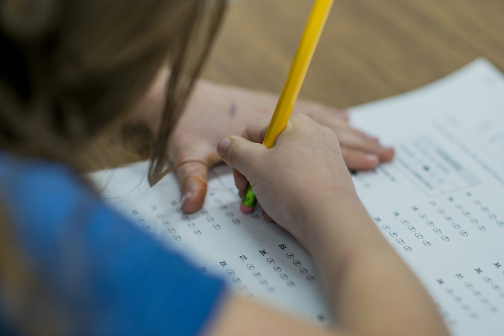 Bild på barn som fyller i ett prov med en blyertspenna
