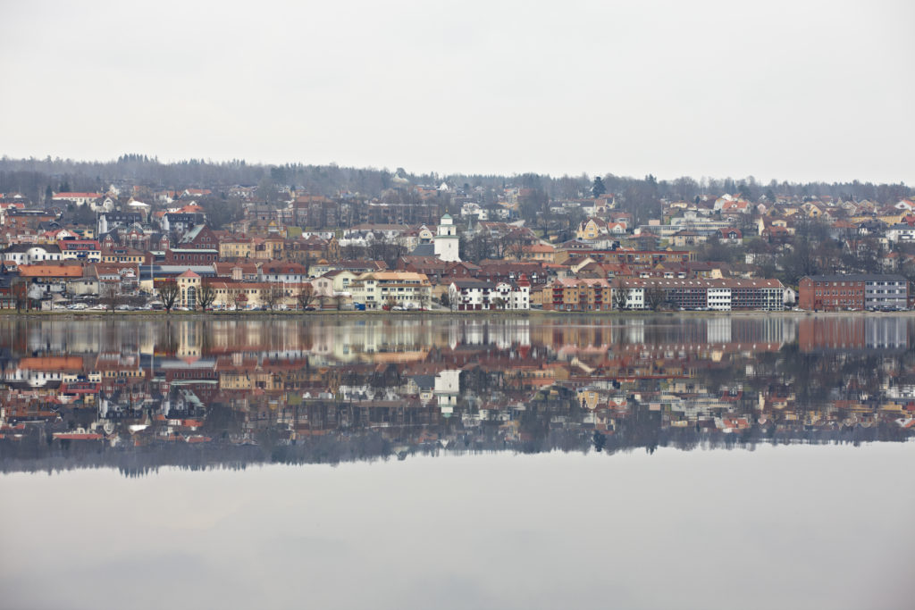 Spegelblankt Åsundenvatten och sedan en stadsvy.