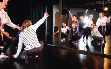 Bild på elever som övar dans framför en stor spegel