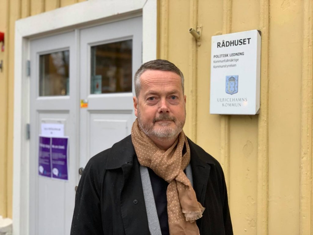 Gustaf Olsson framför rådhusets gula fasad