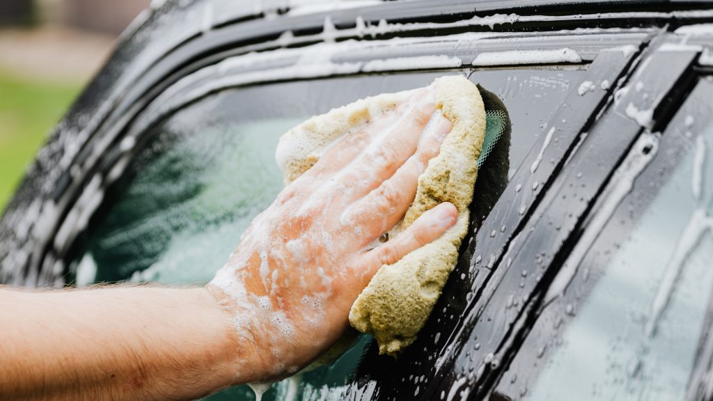 Person som tvättar en bil