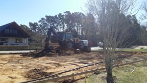 Arbetet med den nya lekplatsen på Ringvägen 2 i Timmele är igång. Bilden visar en jordhög och en traktor som gräver.