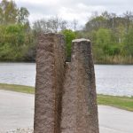 Skulpturen Slowfox i två stenblock ståendes i en rondell.
