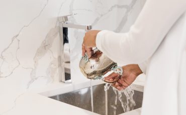 Kvinna diskar i ett marmorerat kök