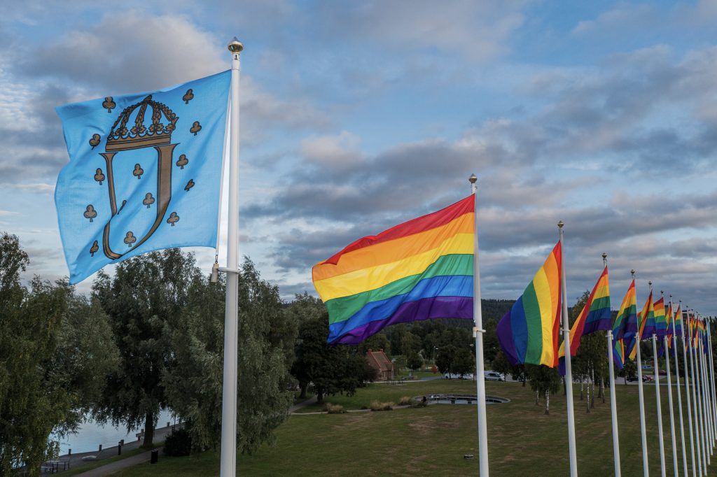 Ulricehamns flagga tillsammans med flera prideflaggor i regnbågens färger