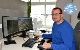 Tommy Lind sitter vid sitt skrivbord på sitt kontor. Framför sig har han två datorskärmar som visar två kartor.