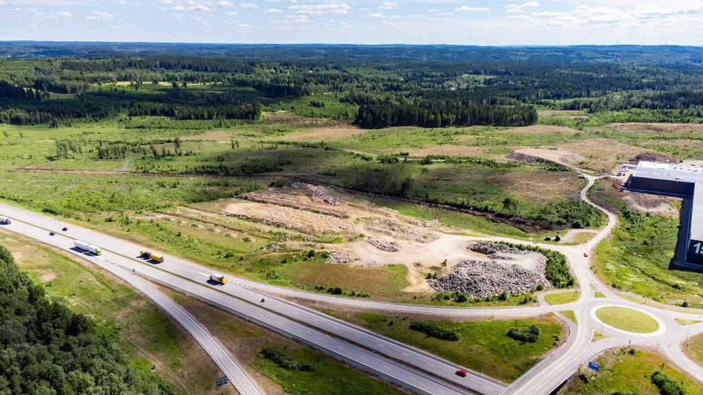 Vy över grönområde, en motorväg och en rondell.