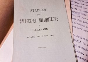 En bild på framsidan på stadgar för Sällskapet Jultomtarne i Ulricehamn från 1907.