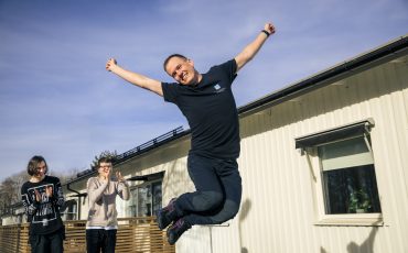 kille som hoppar högt och två andra pojkar tittar på