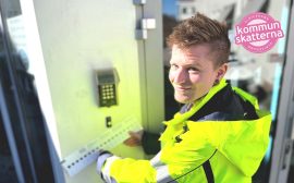 kille i gul varseljacka som knappar på dosa på väggen